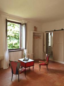 salon z krzesłami, stołem i oknem w obiekcie Villa Amai w mieście Lequio Tanaro