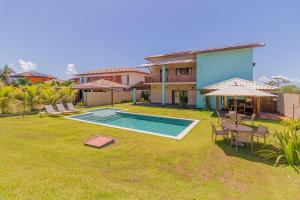 a backyard with a swimming pool and a house at PF55 Ótima Casa 4 Suítes - Praia do Forte in Farol