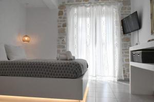 a bedroom with a bed with a teddy bear on it at Sea View Stone House in Naousa