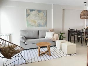a living room with a couch and a table at Check and Home - San Lorenzo - 2 Huéspedes con Pileta y Cochera in Mar del Plata