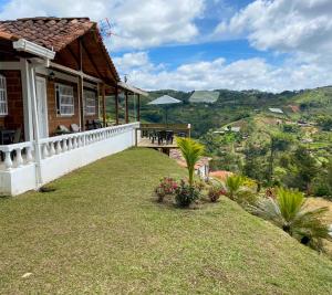 Casa con balcón con mesa y flores en Preciosa finca en el peñol de Guatapé con piscina y jacuzzi, en Guatapé