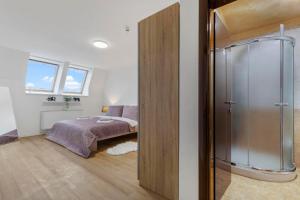a bedroom with a bed and a glass shower at Family Hub in Centre in Bratislava