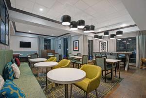 a dining room with tables and yellow chairs at Hampton Inn Keokuk in Keokuk