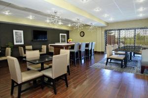 a dining room with a table and chairs and a bar at Hampton Inn Ashtabula in Austinburg