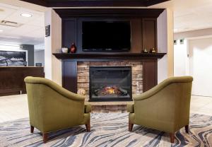 two chairs in front of a fireplace with a tv at Hampton Inn Erie-South in Erie