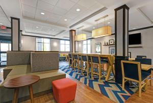 a restaurant with a bar with chairs and a table at Hampton Inn Farmington in Farmington