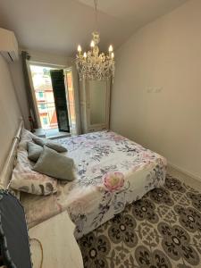 a bedroom with a bed and a chandelier at Delizioso bilocale Mottino23 in Lerici