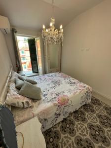 een slaapkamer met een bed en een kroonluchter bij Delizioso bilocale Mottino23 in Lerici