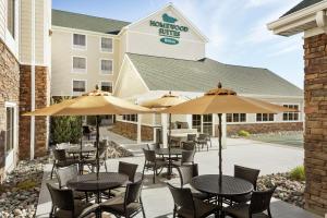 a patio with tables and umbrellas in front of a building at Homewood Suites by Hilton Fargo in Fargo