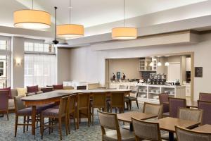 uma sala de jantar com mesas e cadeiras e uma cozinha em Homewood Suites by Hilton Fargo em Fargo