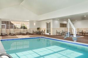 uma piscina num quarto de hotel com cadeiras e mesas em Homewood Suites by Hilton Fargo em Fargo