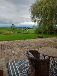 a patio with a table and chairs on a brick patio at Les Abeilles in Prez-vers-Siviriez