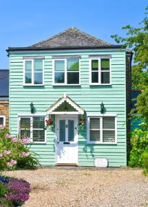 a green house with a white door at The Coach House- Stunning Detached Coastal home, with parking, by Historic Deal Castle in Deal