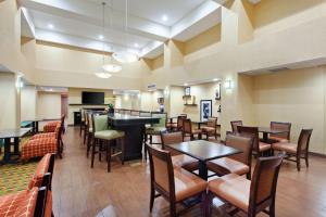a restaurant with tables and chairs and a bar at Hampton Inn & Suites Fresno - Northwest in Herndon
