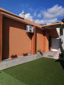 ein Haus mit grünem Rasen davor in der Unterkunft Apartman Petovic in Kotor