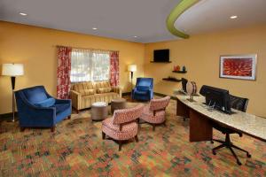 Habitación de hotel con escritorio, sillas y sala de estar. en Hampton Inn Fayetteville Fort Liberty, en Fayetteville
