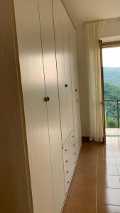 a room with white cabinets and a large window at Il Ciliegio in Stella Cilento