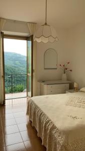 a bedroom with a large bed and a large window at Il Ciliegio in Stella Cilento