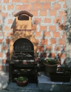 a brick wall with a fireplace with two potted plants at Apartman Petovic in Kotor