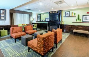 a waiting room with chairs and a fireplace at Hampton Inn Spring Lake Fayetteville in Spring Lake