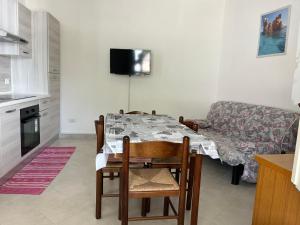 una sala da pranzo con tavolo e divano di SA DOMU DE S'ORTU a Bari Sardo