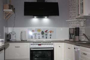 a kitchen with a stove and a tv on the wall at Haus Lebenswert, Ferienhaus in Schneverdingen