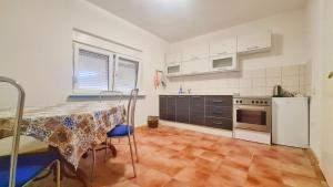 a kitchen with a table and a stove top oven at Apartments Discovery 2 in Ljubuški