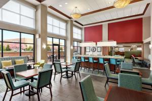 a restaurant with tables and chairs and windows at Hampton Inn & Suites Frederick/Fort Detrick in Frederick