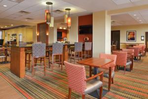 Hampton Inn Frederick في فريدريك: منطقة لتناول الطعام مع طاولات وكراسي في غرفة في الفندق