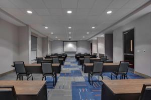 una sala de conferencias con mesas, sillas y una pantalla en Hampton Inn & Suites Fort Lauderdale - Miramar en Miramar