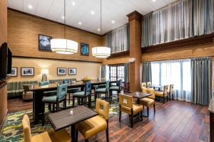 um restaurante com mesas, cadeiras e janelas em Hampton Inn & Suites Florence Center em Florence