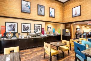 a restaurant with tables and chairs and a bar at Hampton Inn & Suites Florence Center in Florence