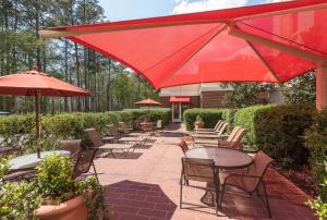 a patio with tables and chairs and umbrellas at Hampton Inn & Suites Florence-North-I-95 in Florence
