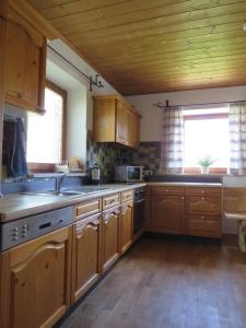 a kitchen with wooden cabinets and a wooden floor at Haus Erle in Peiting