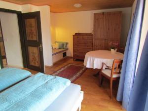a bedroom with a bed and a table and a dresser at Haus Erle in Peiting