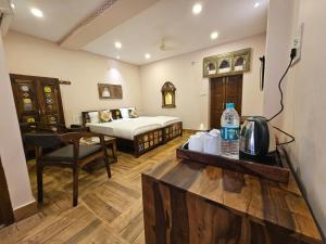 a hotel room with a bed and a table with a water bottle at Khamma Heritage in Jodhpur