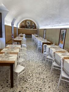 une salle à manger avec des tables et des chaises blanches dans l'établissement La Locanda del Convento, à Tropea