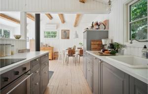 uma cozinha com armários brancos e piso em madeira em Lovely Home In Grevinge With Wifi em Grevinge