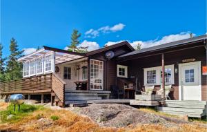 a wooden house with a large rock in front of it at Stunning Home In Risdal With 3 Bedrooms in Mjåvatn