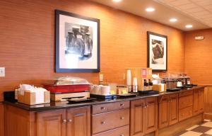a restaurant with a counter with many items on it at Hampton Inn & Suites Fremont in Fremont