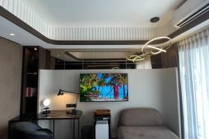 Cette chambre dispose d'un canapé et d'une télévision murale. dans l'établissement Cozy Studio at Amarta Apartment, à Yogyakarta