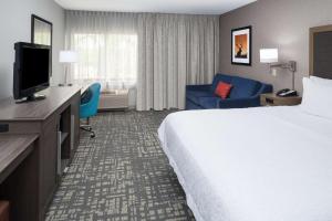 a hotel room with a large bed and a television at Hampton Inn North Sioux City in North Sioux City