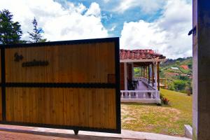 una puerta de madera frente a una casa con cenador en Preciosa finca en el peñol de Guatapé con piscina y jacuzzi, en Guatapé