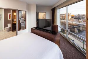 ein Hotelzimmer mit einem Bett und einem großen Fenster in der Unterkunft Hilton Garden Inn Sioux Falls Downtown in Sioux Falls