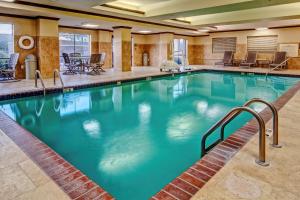 una piscina en una habitación de hotel con mesas y sillas en Hampton Inn Van Buren, en Van Buren