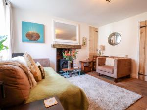 a living room with a couch and a fireplace at Harmony Cottage in Bungay