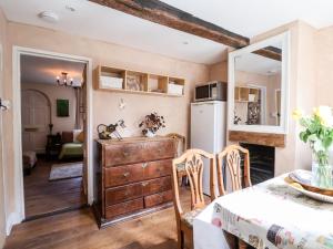 a kitchen and dining room with a table and a refrigerator at Harmony Cottage in Bungay