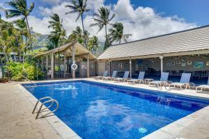 a swimming pool with chairs and a building at Kaunakakai Condo with Private Lanai and Ocean Views! in Kaunakakai