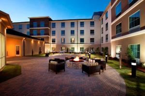 une cour avec des chaises et un foyer extérieur en face d'un bâtiment dans l'établissement Homewood Suites by Hilton Fort Worth West at Cityview, à Fort Worth