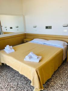 a hotel room with a bed with towels on it at Hotel Columbia Frontemare in Rimini